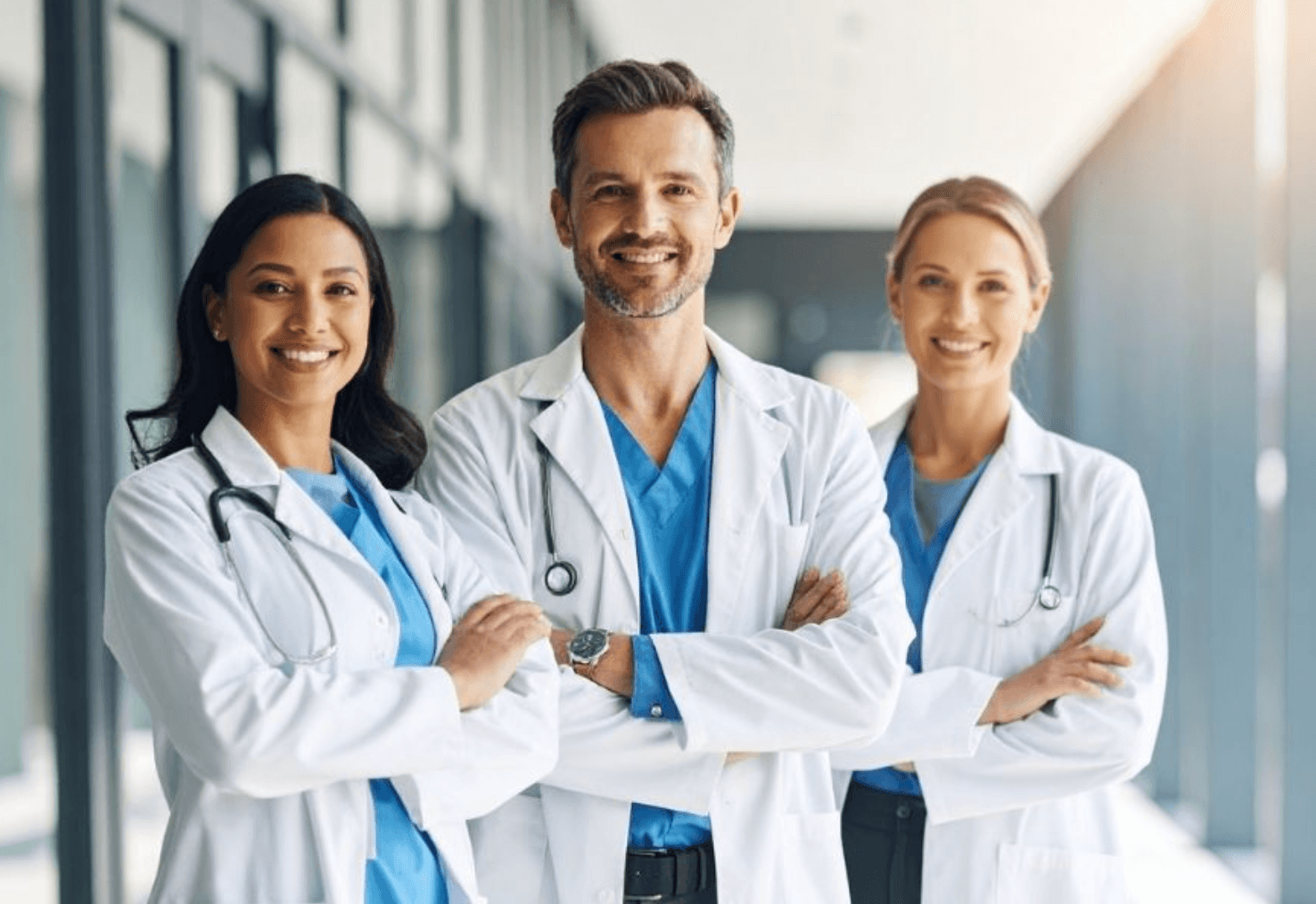 Three doctors standing together in a clinic hallway